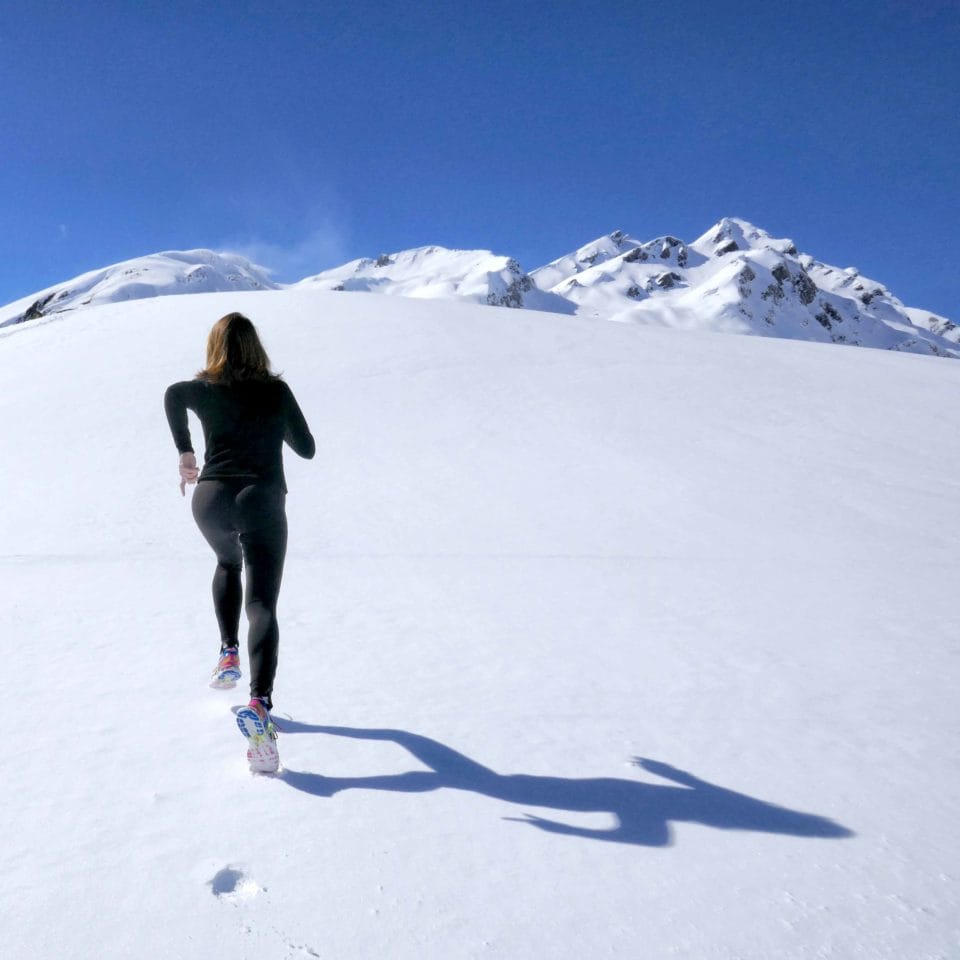 woman running on snowy mountain