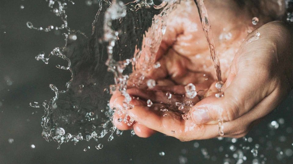 person washing their hands under a flow of water